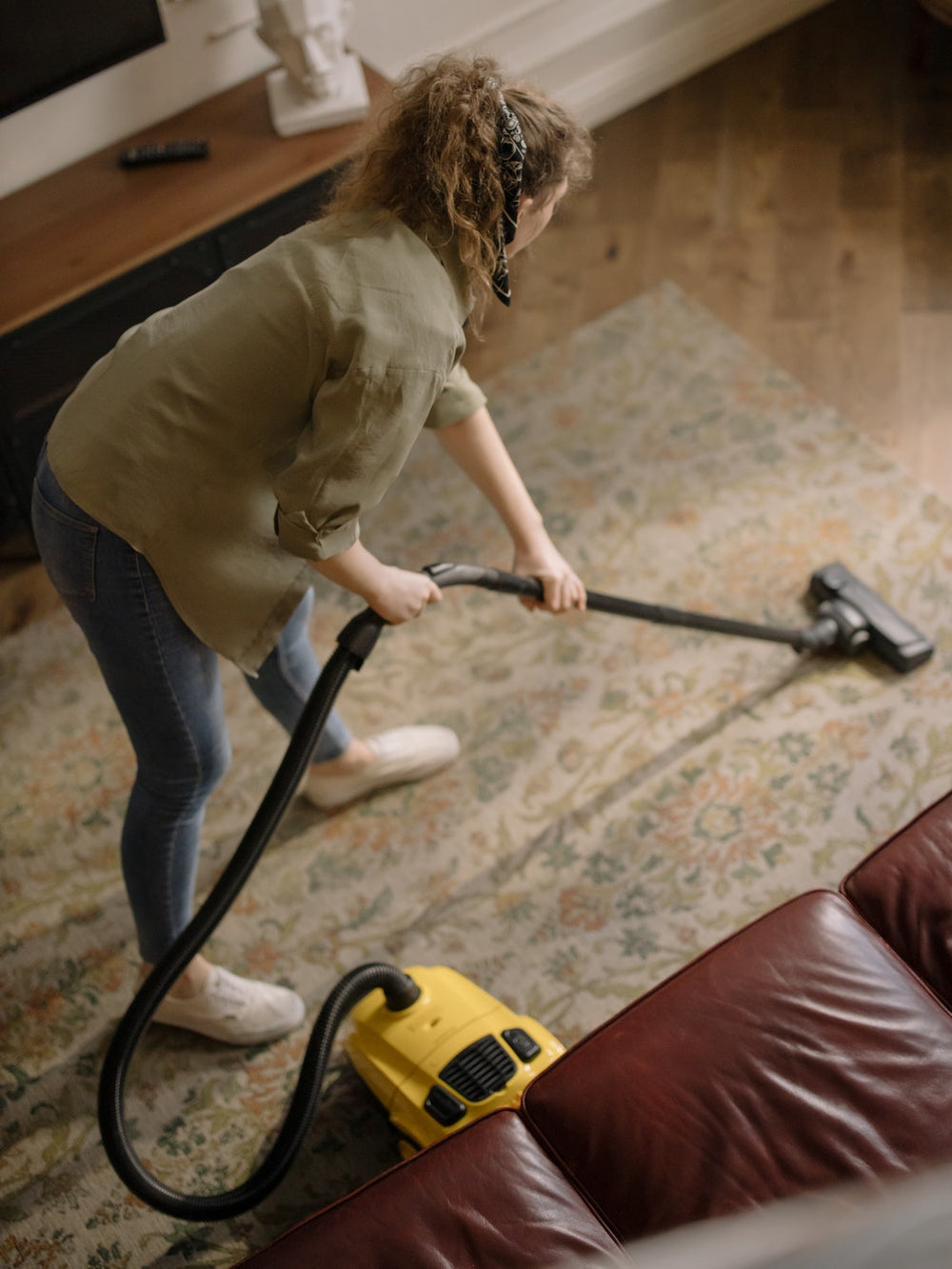 woman vacuuming rug in her home