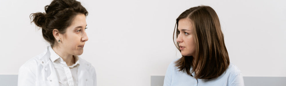 Pregnant woman sitting with her doctor